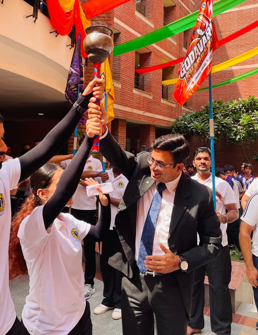 Dr Ajay Rana with students holding the university torch